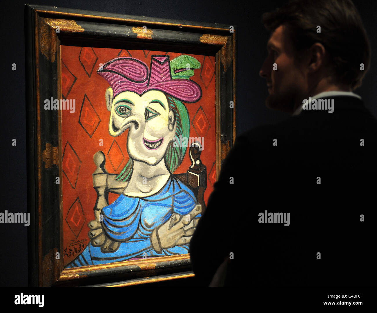 Un potenziale acquirente studia il dipinto di Pablo Picasso (1881-1973) intitolato Dora Maar, che è valutato a 4/8 milioni ed è uno dei numerosi capolavori che lancerà una stagione di quattro settimane di aste che si prevede di vendere per un totale di 250 milioni, a Christie's nel centro di Londra. Foto Stock