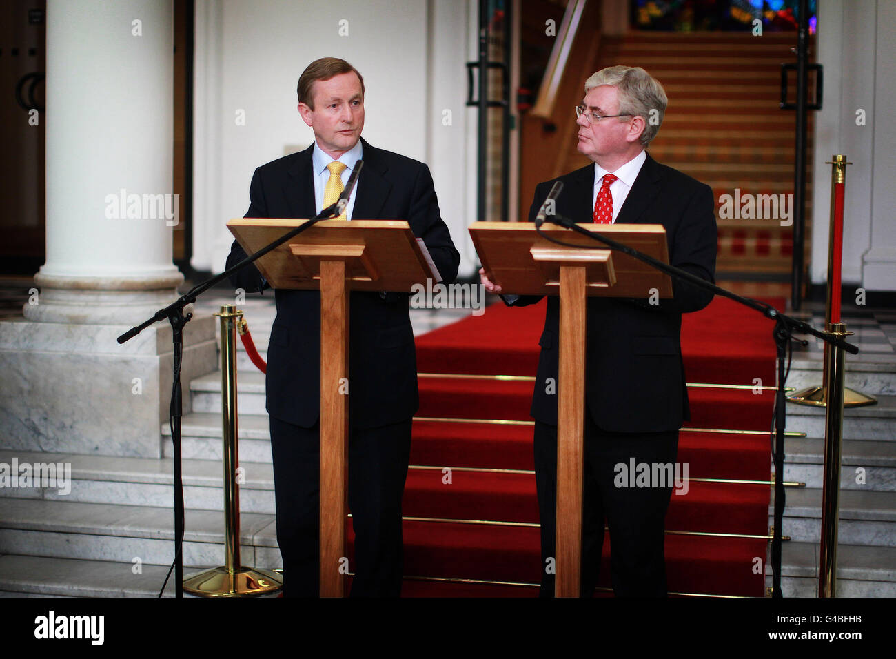 Taoiseach Enda Kenny (sinistra) e Tanaiste Eamon Gilmore (destra) presso gli edifici governativi questa sera per una conferenza stampa sui primi 100 giorni del Governo. Il governo si è impegnato a non alzare l'imposta sul reddito o a tagliare i pagamenti dole in bilancio, in quanto segna i suoi primi 100 giorni in carica. Foto Stock