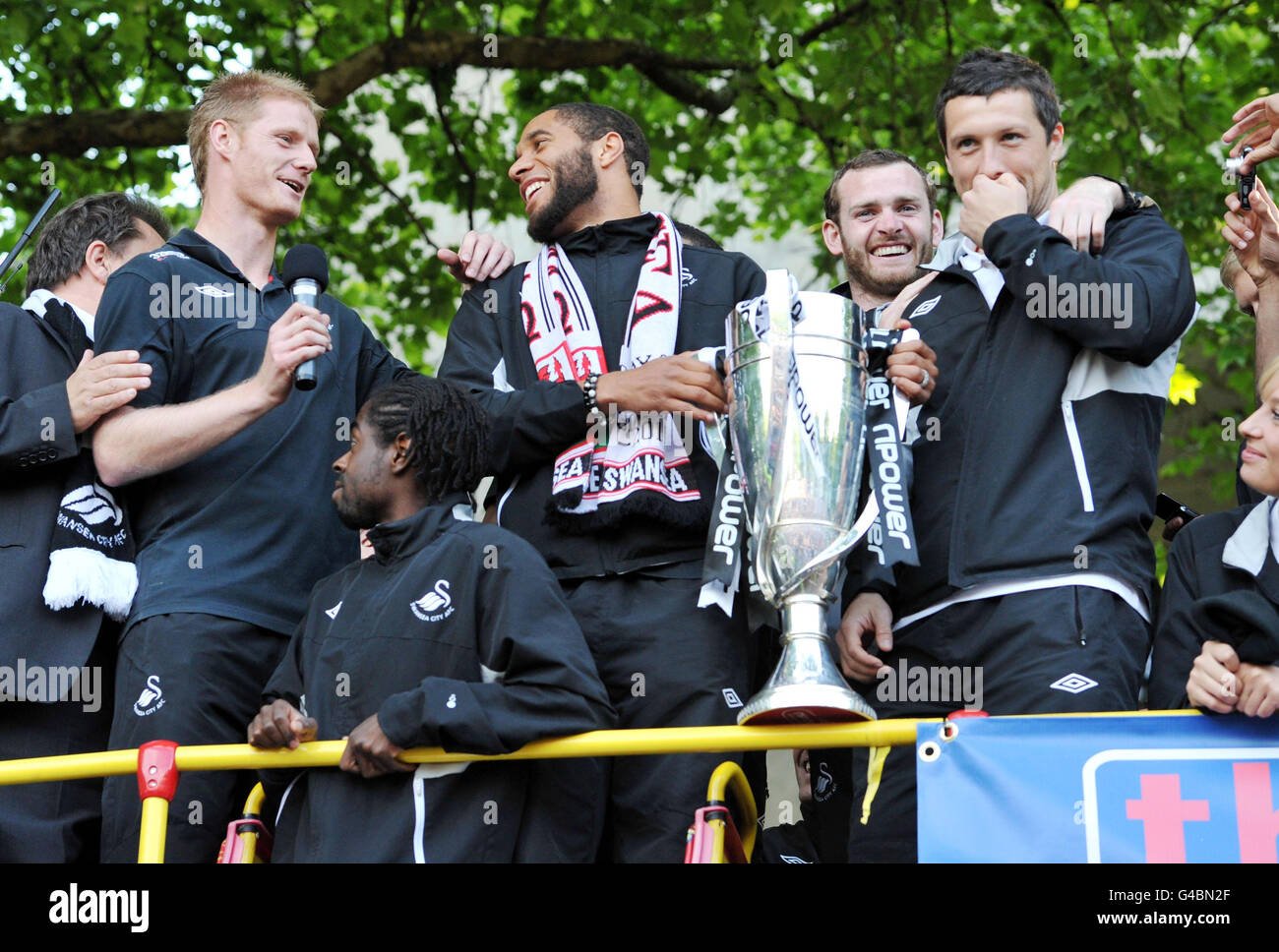 Swansea's (da sinistra) Alan Tate, Nathan Dyer, Ashley Williams e Craig Beattie in cima all'autobus dopo che è arrivato a Swansea Guildhall durante la sfilata di autobus attraverso Swansea. Foto Stock