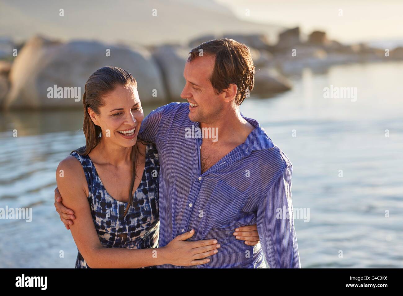 Modello rilasciato. Coppia da parte del mare con le braccia intorno all'altro. Foto Stock