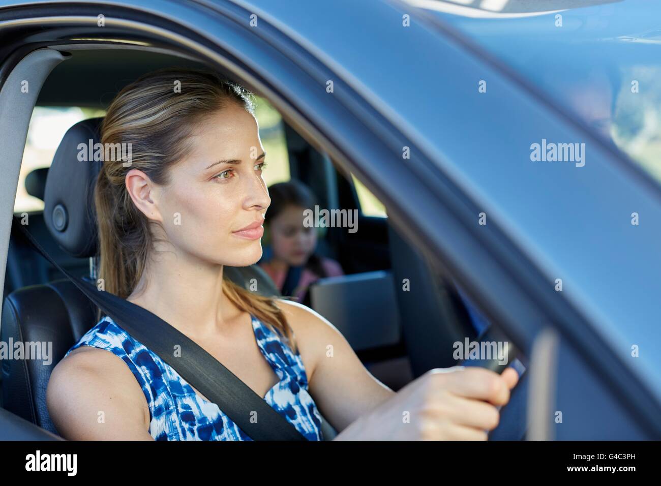 Modello rilasciato. Giovane donna alla guida di auto. Foto Stock