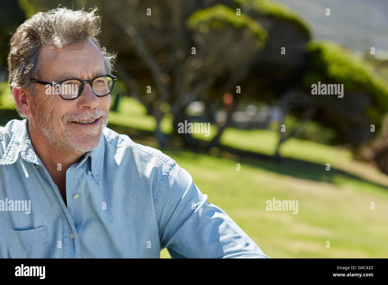 Modello rilasciato. L'uomo anziano con gli occhiali e camicia, sorridente. Foto Stock