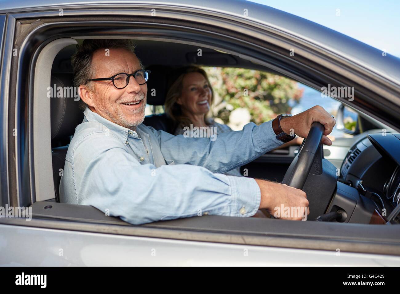 Modello rilasciato. Senior uomo in auto, sorridente. Foto Stock