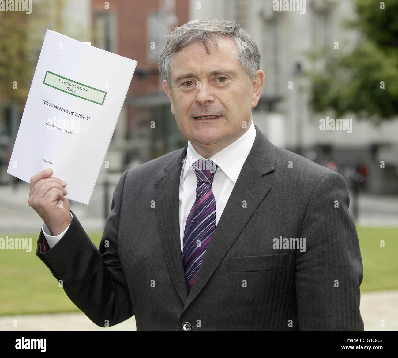 Il ministro delle spese pubbliche e delle riforme Brendan Howlin si rivolge ai media sulla pubblicazione della prima revisione dell'attuazione dell'accordo di Croke Park presso gli edifici governativi di Dublino. Foto Stock