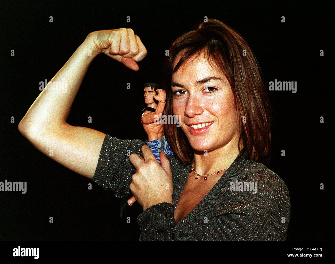PA NEWS PHOTO 21/4/98 TARA PALMER TOMKINSON PONE CON UNA BAMBOLA DELL'UOMO D'AZIONE CHE FLETTE I SUOI MUSCOLI IN UNA COMPETIZIONE PER TROVARE L'UOMO D'AZIONE VIVENTE REALE CHE APPARE ALLE APPARIZIONI PUBBLICHE A LONDRA Foto Stock
