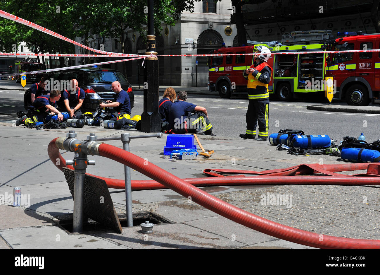 Fuoco sullo Strand. I vigili del fuoco affrontano un bizzarri sul tetto di un edificio in costruzione sullo Strand di Londra. Foto Stock