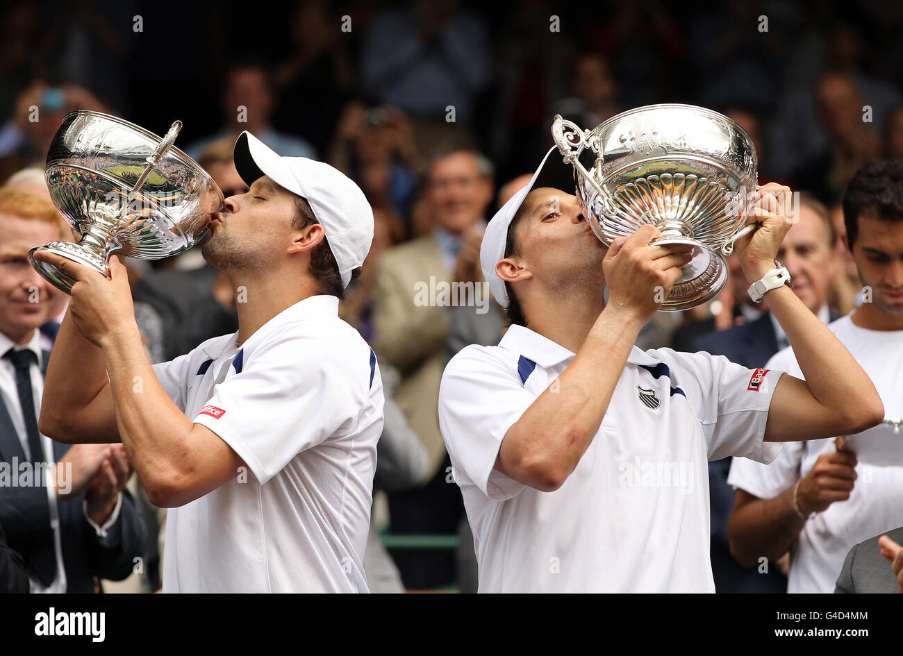 Bob (a sinistra) e Mike Bryan degli Stati Uniti festeggiano con i loro trofei dopo aver sconfitto Robert Lindstedt svedese e Horia Tecau della Romania nella loro finale di GEN's Doubles durante il giorno dodici dei Campionati Wimbledon 2011 all'All England Lawn Tennis and Croquet Club di Wimbledon. Foto Stock