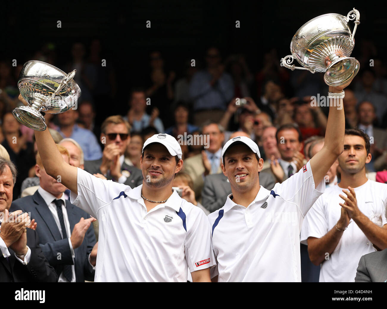 Bob (a sinistra) e Mike Bryan degli Stati Uniti festeggiano con i loro trofei dopo aver sconfitto Robert Lindstedt svedese e Horia Tecau della Romania nella loro finale di GEN's Doubles durante il giorno dodici dei Campionati Wimbledon 2011 all'All England Lawn Tennis and Croquet Club di Wimbledon. Foto Stock