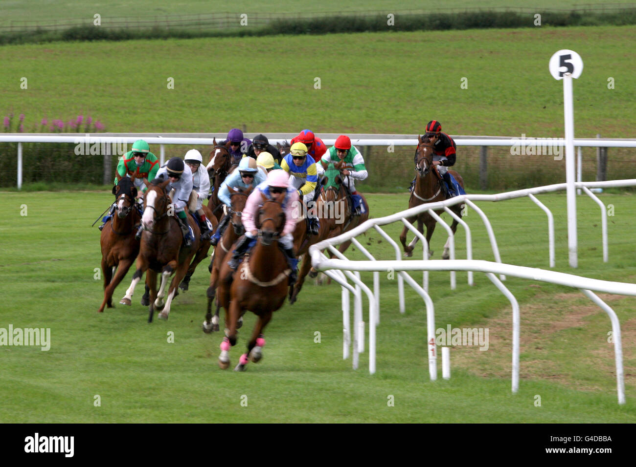 Corse di cavalli - Summer Race Night - Ippodromo di Chepstow. I corridori e i corridori corrono il corso durante il handicap del concessionario Kubota del macchinario di SJH Foto Stock