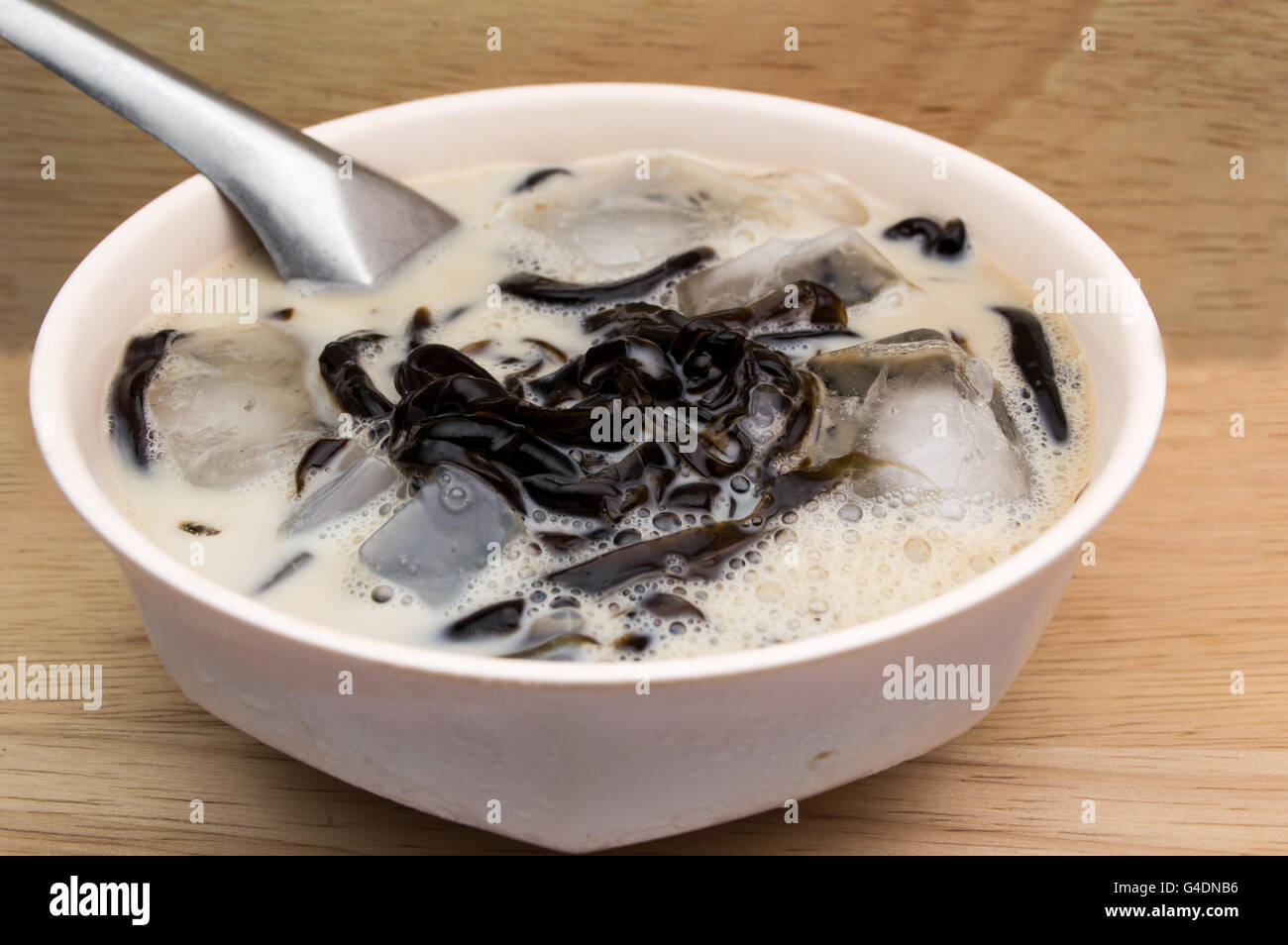 Gelatina di erba latte di ghiaccio in una coppa di rosa e uno sfondo di legno Foto Stock