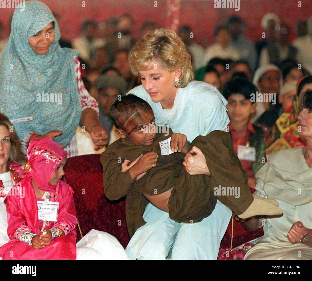 Nota per i redattori: Questa immagine trasmessa il 17 agosto 1998 per accompagnare un pacchetto di storie prima del primo anniversario della morte di Diana, Principessa del Galles. File della biblioteca, datato 22.2.96, di Diana, Principessa del Galles, che cullava un bambino malato in un ricevimento tenuto presso l'ospedale per il cancro Shaukat Khanum durante la sua visita in Pakistan l'anno scorso. Foto di John Giles.PA. Foto Stock