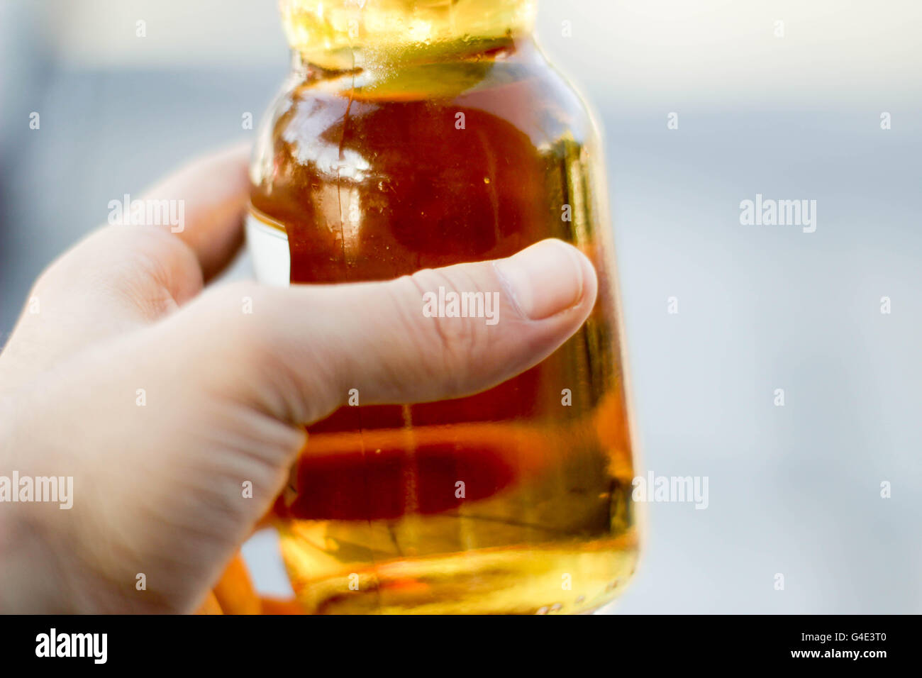 Fotografia di una mano che afferra una bottiglia di birra Foto Stock