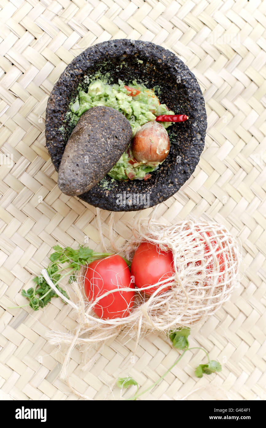 Fotografia di fracassato advocado, guacamole in un tradizionale di pietra molcajete Foto Stock