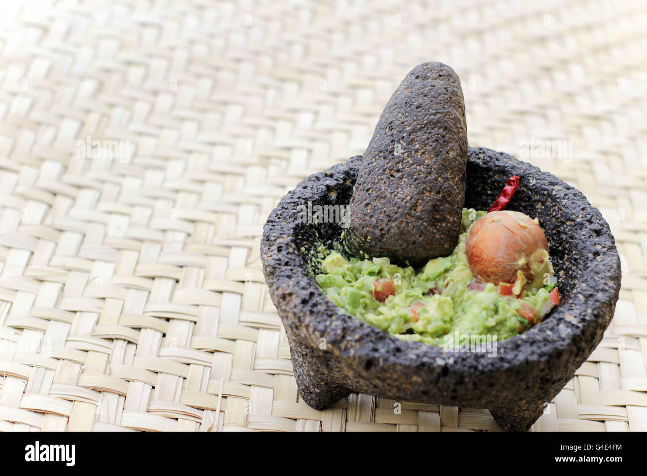 Fotografia di fracassato advocado, guacamole in un tradizionale di pietra molcajete Foto Stock