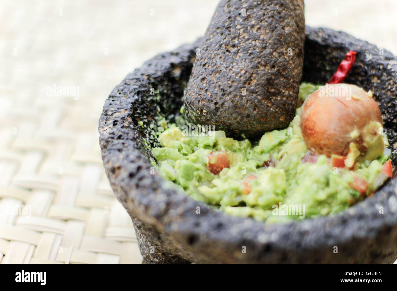 Fotografia di fracassato advocado, guacamole in un tradizionale di pietra molcajete Foto Stock