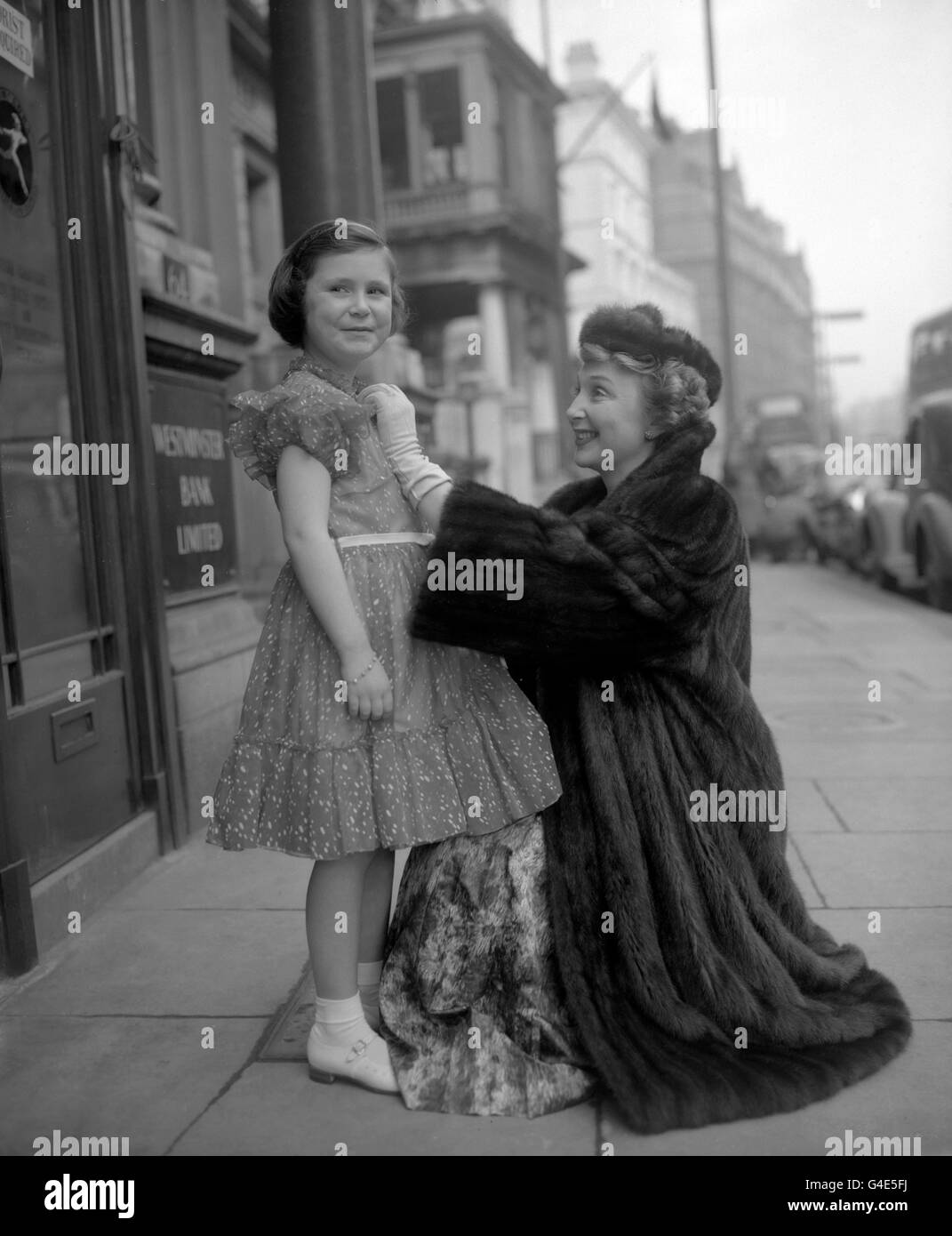 Joanna McCallum, di sei anni, ha ricevuto un'ispezione finale dalla madre, l'attrice Googie Withers, prima di entrare nell'Hyde Park Hotel di Londra, per il Blue Bird Party, un evento per bambini in aiuto della League of Pity. Foto Stock