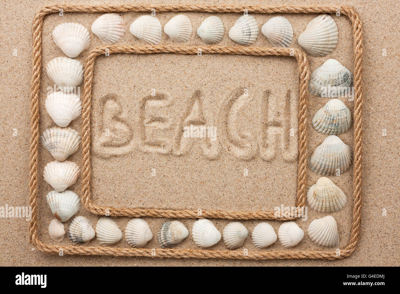 Bella cornice di corda e conchiglie sulla sabbia con iscrizione spiaggia , come sfondo Foto Stock