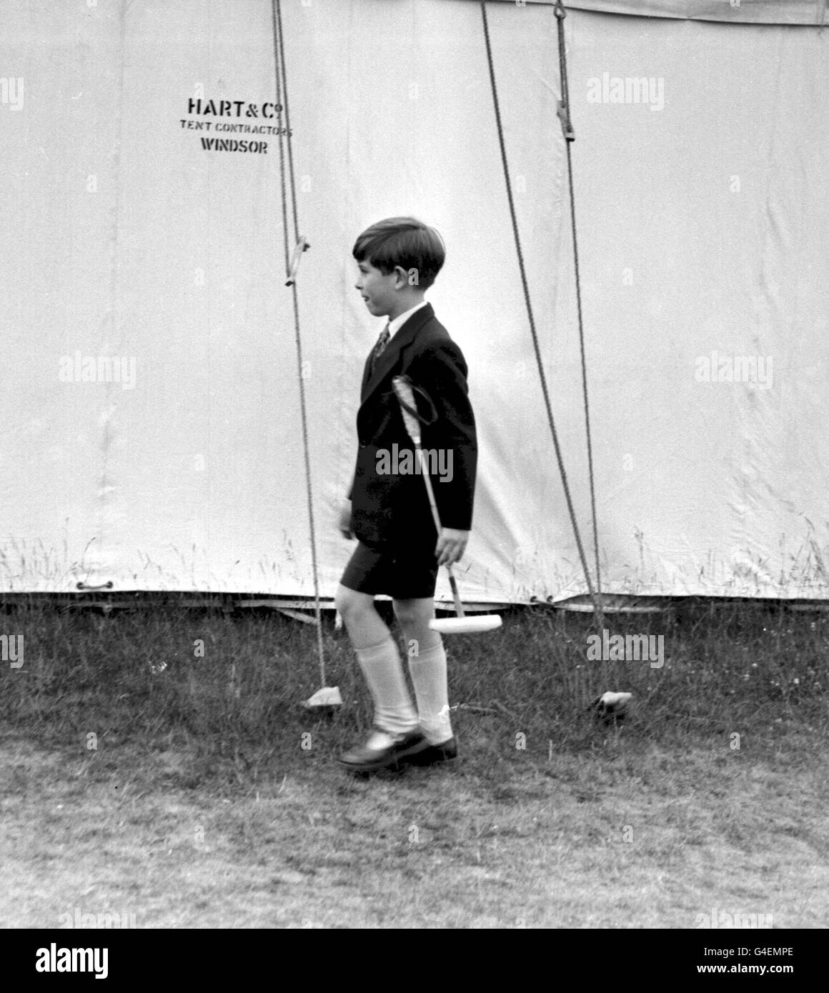 PA NEWS FOTO 23/6/57 Il principe del Galles con un polo in miniatura stick si allontana dal tendone a SMITH PRATO Windsor Great Park, dove egli ha accompagnato gli altri membri della famiglia reale per le finali di ROYAL WINDSOR CUP torneo di polo Foto Stock