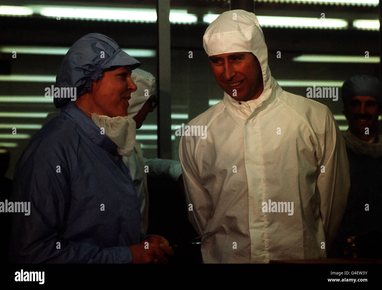 PA NEWS PHOTO 25/2/83 IL PRINCIPE CARLO INDOSSA UN 'BUNNY SUIT' BIANCO MENTRE CHIACCHIERA CON UN LAVORATORE PRESSO LA FABBRICA INMOS DI 20 MILIONI A NEWPORT, GWENT. Foto Stock