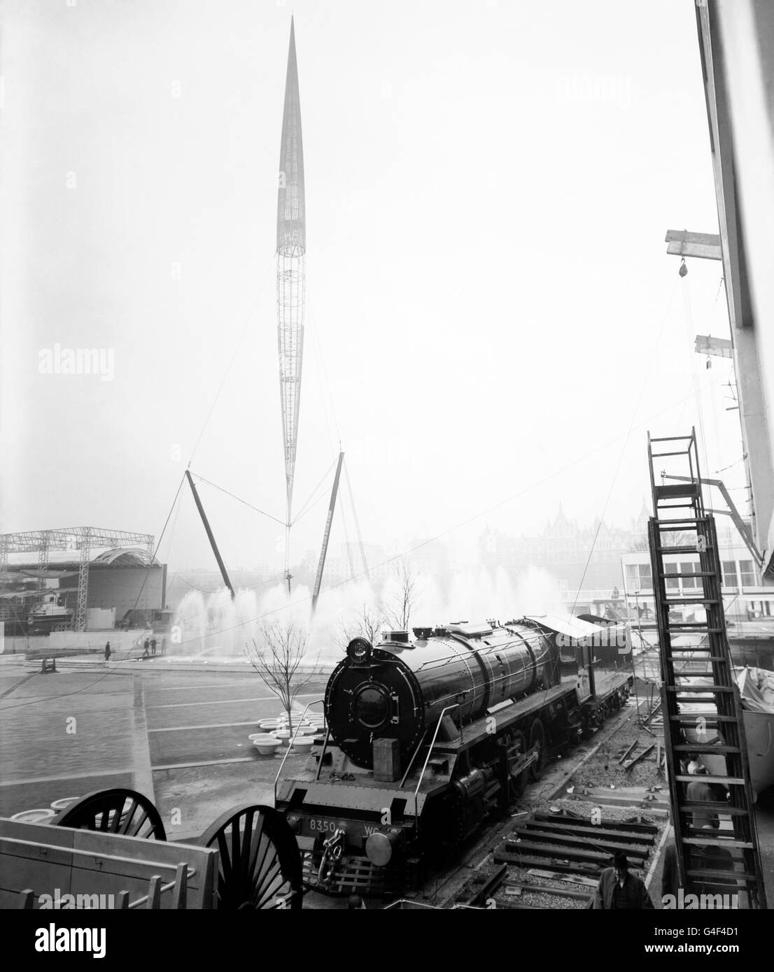 Dito del futuro, lo Skylon si trova sopra le sue fontane e una locomotiva gigante in questa anteprima del Festival of Britain sul sito South Bank Exhibition. Le fontane, che sono state completamente testate per la prima volta, fiancheggiano la base del Skylon alto 290 piedi. La locomotiva da 173 tonnellate è stata costruita a Glasgow per le Ferrovie del governo indiano e viene presentata all'esposizione prima di andare all'estero. Foto Stock