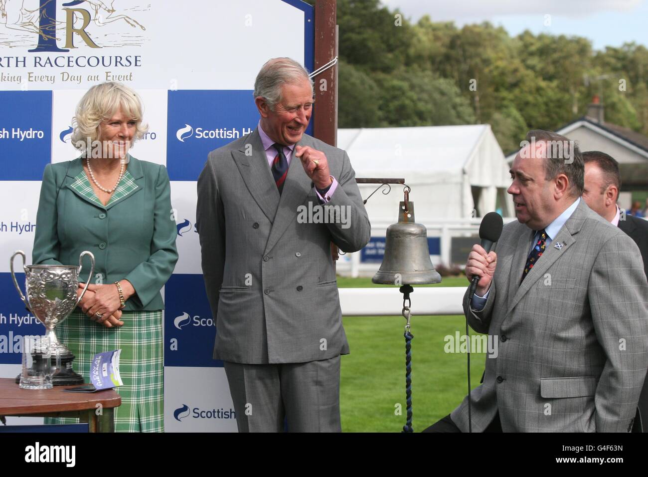 Il Principe di Galles e la Duchessa di Cornovaglia con il primo Ministro scozzese Alex Salmond (a destra) in una giornata di gara di beneficenza all'ippodromo di Perth in Scozia. Foto Stock