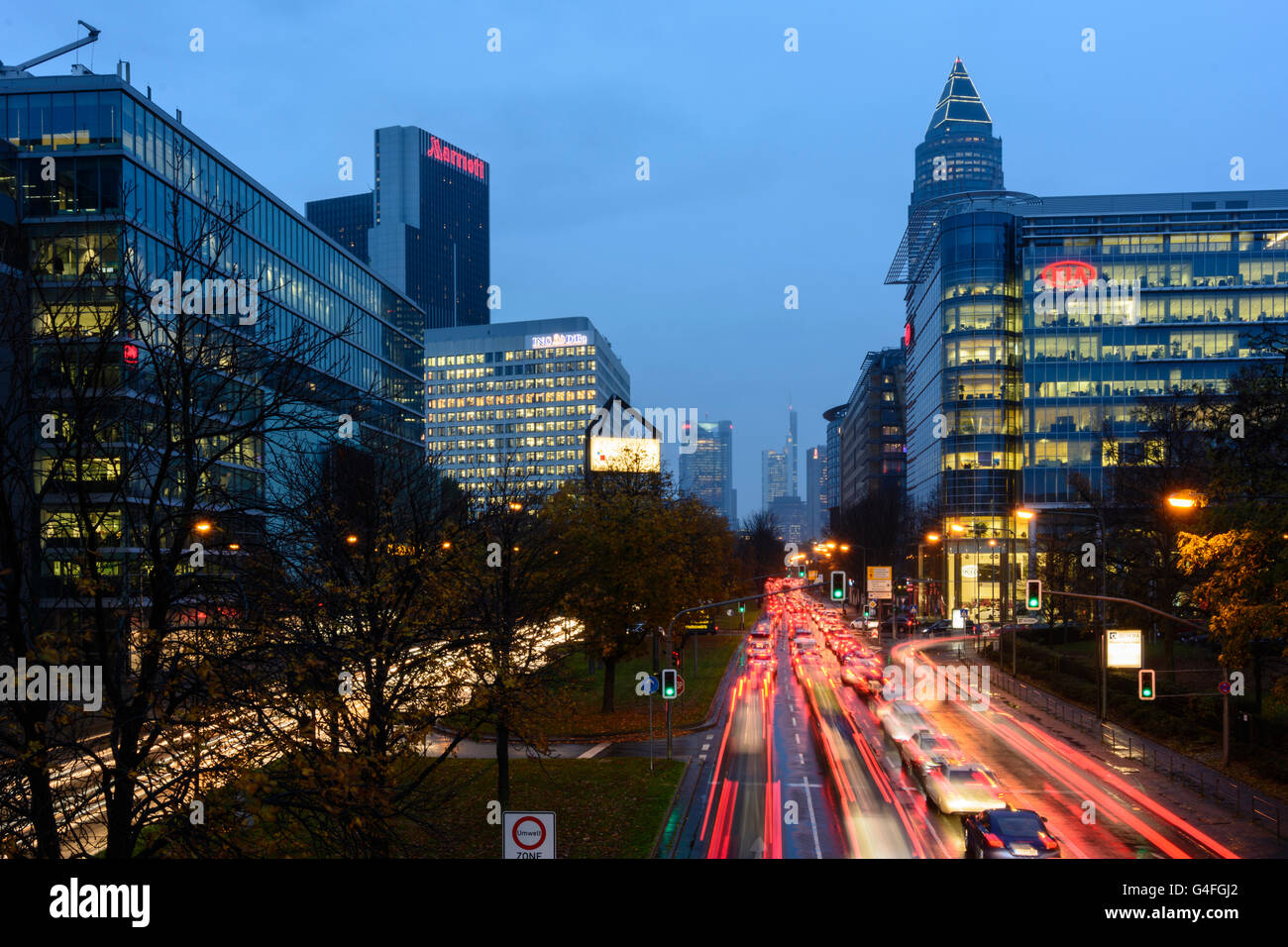 Theodor - Heuss-Allee con vetture in ingorghi di traffico , la notte e la pioggia con una vista al centro della città con la Torre della Commerzbank e Me Foto Stock
