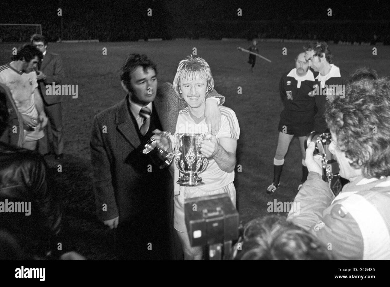 Il manager della foresta di Nottingham Brian Clough mette il suo braccio Kenny Burns mentre tiene con orgoglio il trofeo della League Cup a Old Trafford dopo aver battuto Liverpool nel replay finale della League Cup. Foto Stock