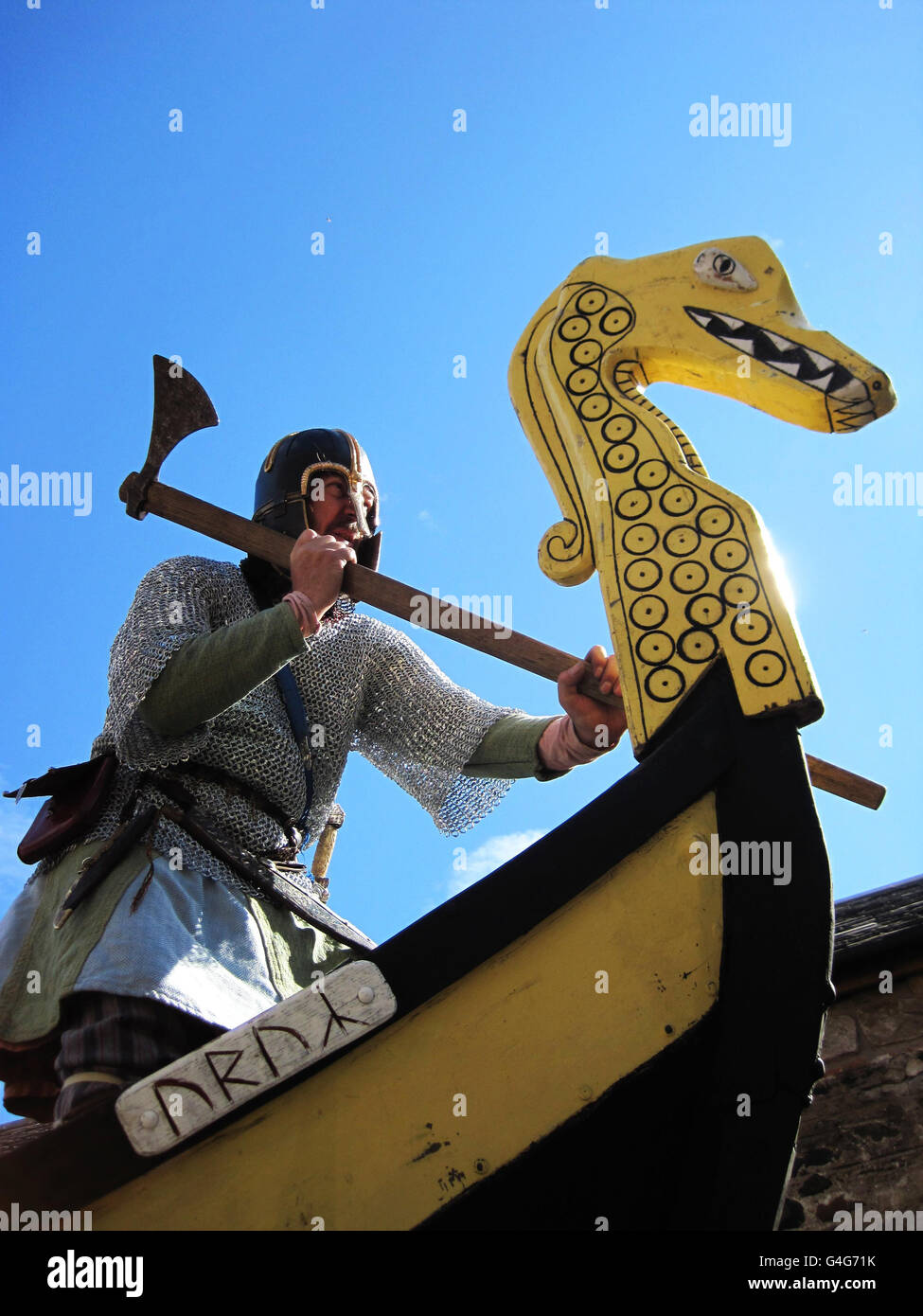 Russell Scott, padre di due sposati di Cheddleton, vicino a Leek, nello Staffordshire, gioca il capo dei vichinghi Rigr sulla prow della longship a Lindisfarne, Northumberland, per lanciare un festival culturale. Foto Stock