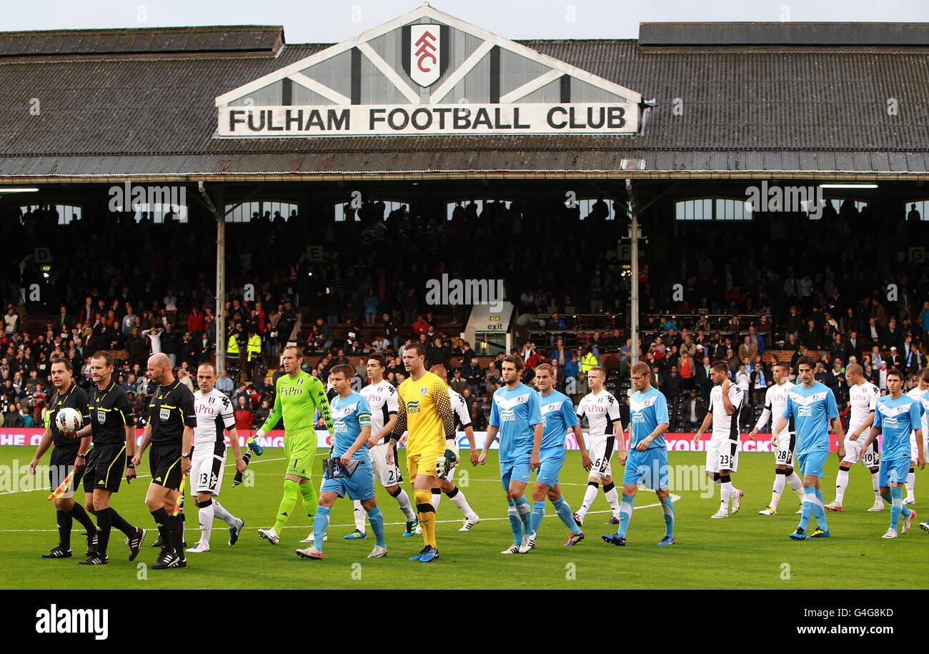 Calcio - UEFA Europa League - Play offs - prima tappa - Fulham v Dnipro - Craven Cottage. Fulham e Dnipro, guidati dai funzionari della partita, entrano in campo prima del calcio d'inizio Foto Stock