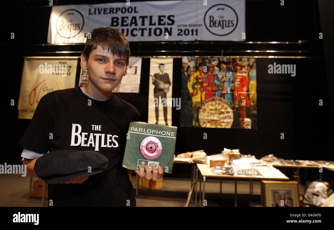 Kyle Macdonald ha un berretto indossato da John Lennon e una copia da 7 pollici dell'album Please Me, firmato su entrambi i lati dal Fab Four e atteso per recuperare migliaia di sterline alla Liverpool Beatles Auction, Liverpool Institute for Performing Arts School. Foto Stock