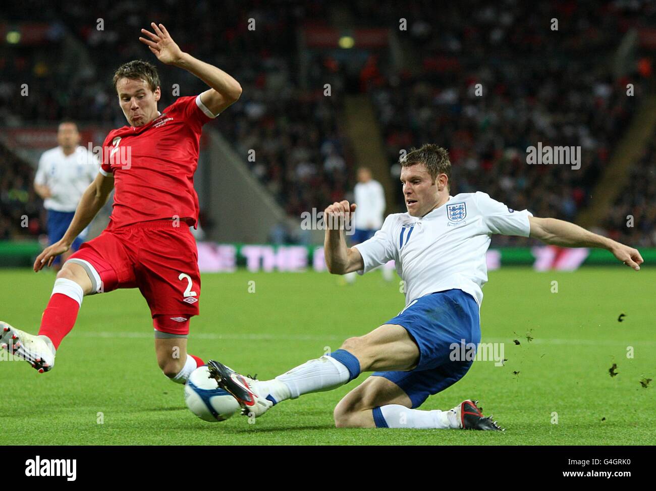 Chris Gunter (a sinistra) del Galles tenta di bloccare una croce da James Milner in Inghilterra (a destra) Foto Stock