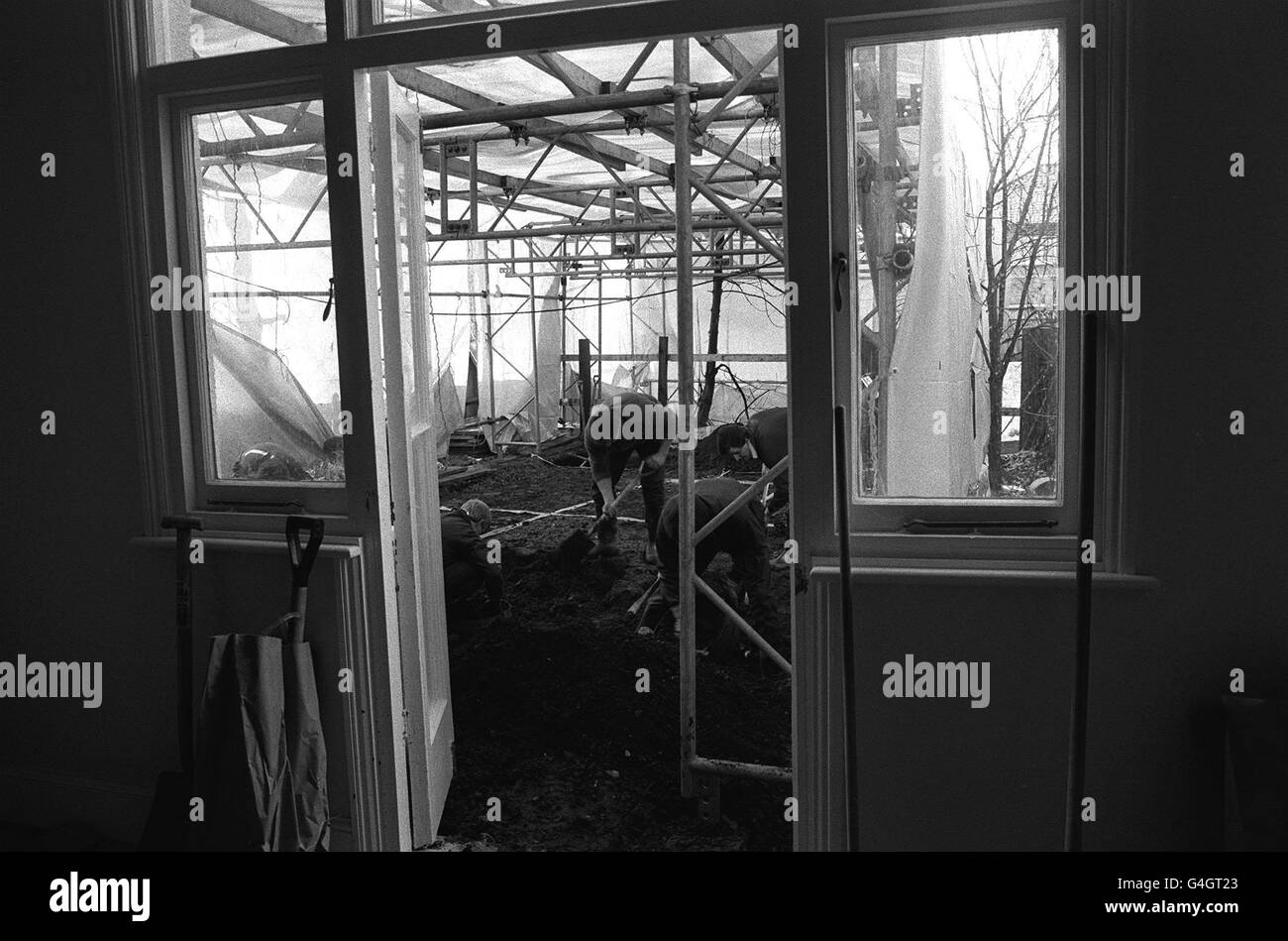 Una vista attraverso la porta posteriore della casa a Melrose Avenue Londra, dove la polizia sta scavando e setacciando la terra sotto una tenda di plastica. La ricerca di resti umani continua. Si pensa che vi siano sepolti fino a 13 corpi. Foto Stock