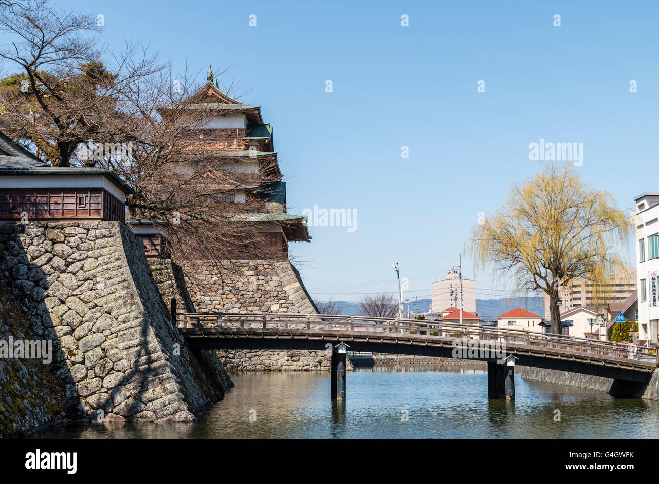 Giappone, Suwa. Ricostruito il castello di Takashima. Kabukibashi ponte di legno ingresso oltre il fossato, con la principale tenere. La primavera con cielo blu chiaro. Foto Stock