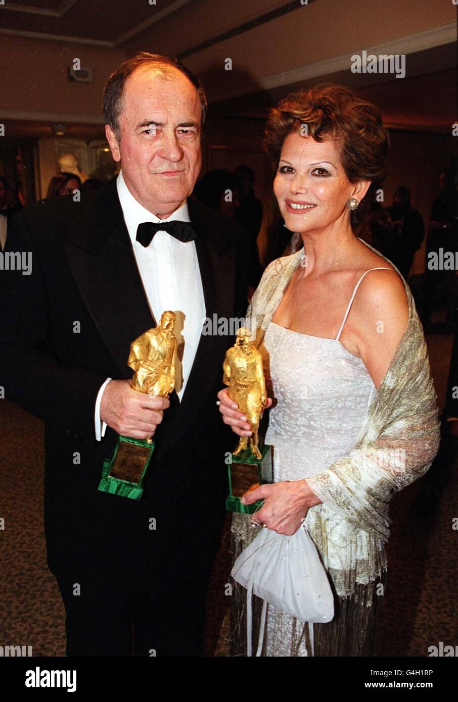 Il regista Bernado Bertolucci e l'attrice Claudia Cardinale con il Rudolph Valentino Award per il successo a vita nel cinema, al Grosvenor House Hotel di Londra. I premi si tengono ogni anno in diverse località. Foto Stock