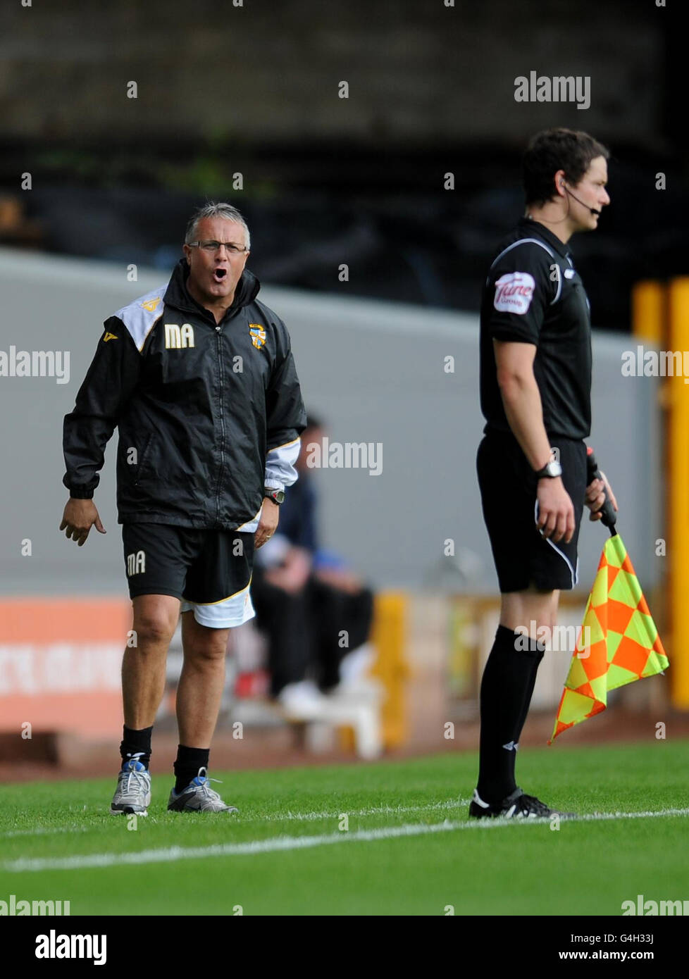 Il manager di Port vale Micky Adams (a sinistra) sfiora la sua frustrazione verso l'assistente dell'arbitro durante la partita della Npower Football League Two al vale Park, Stoke on Trent. Foto Stock