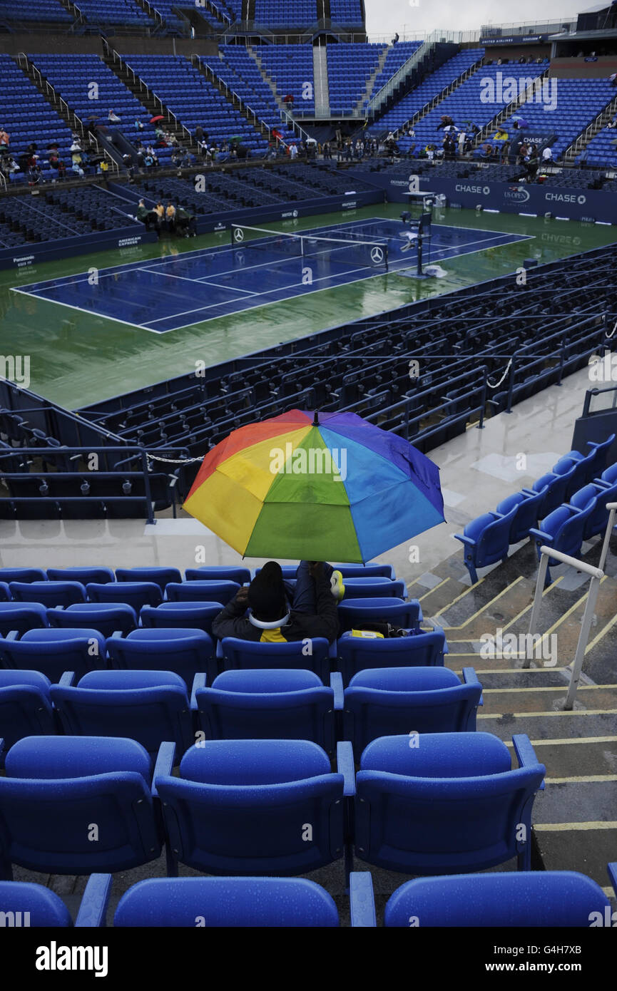 Tennis - 2011 US Open - giorno dieci - Flushing Meadows. Gli spettatori si siedono sotto gli ombrelloni mentre i ritardi della pioggia giocano durante il giorno dieci dell'Open degli Stati Uniti a Flushing Meadows, New York, USA. Foto Stock