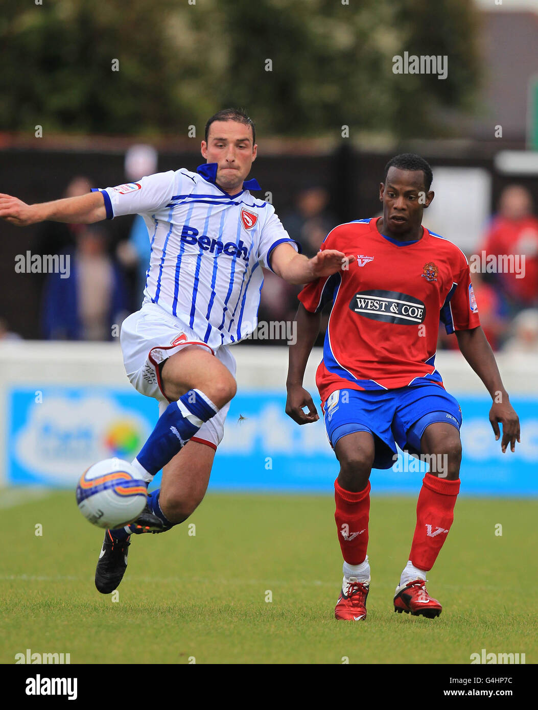 Chris McCready di Morecombe sfida Jon Nurse di Dagenham e Redbridge durante la partita della Npower Football League Two a Victoria Road, Dagenham. Foto Stock