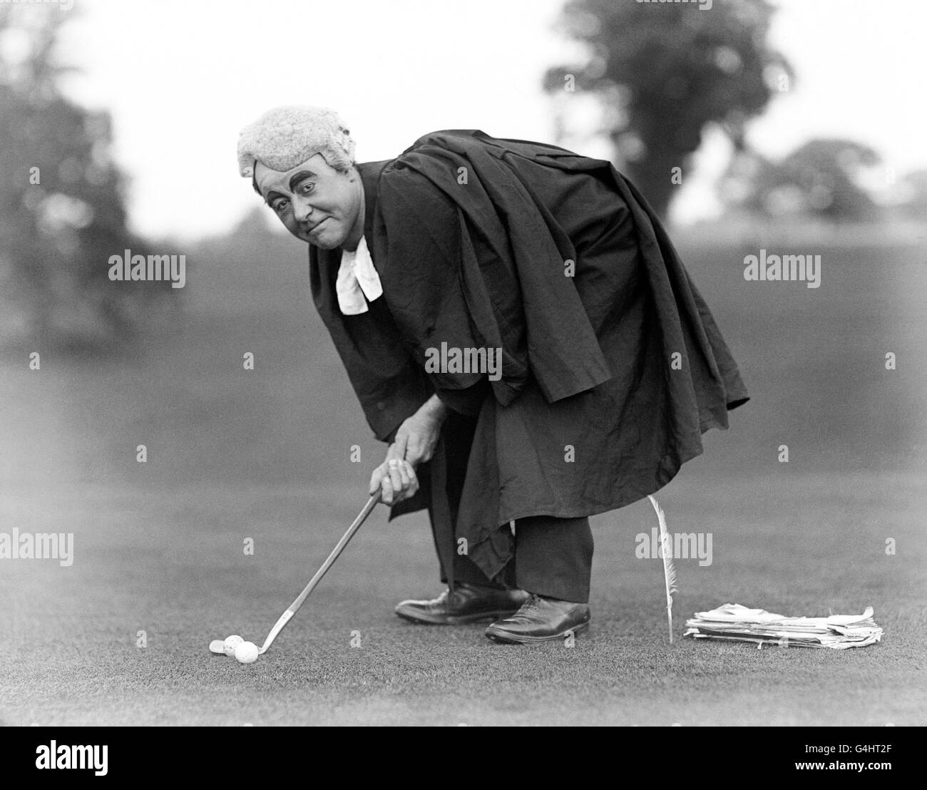 British Theatre & Music Hall - George Robey. Il comico George Robey, in abiti legali e parrucca, giocando a golf. Foto Stock