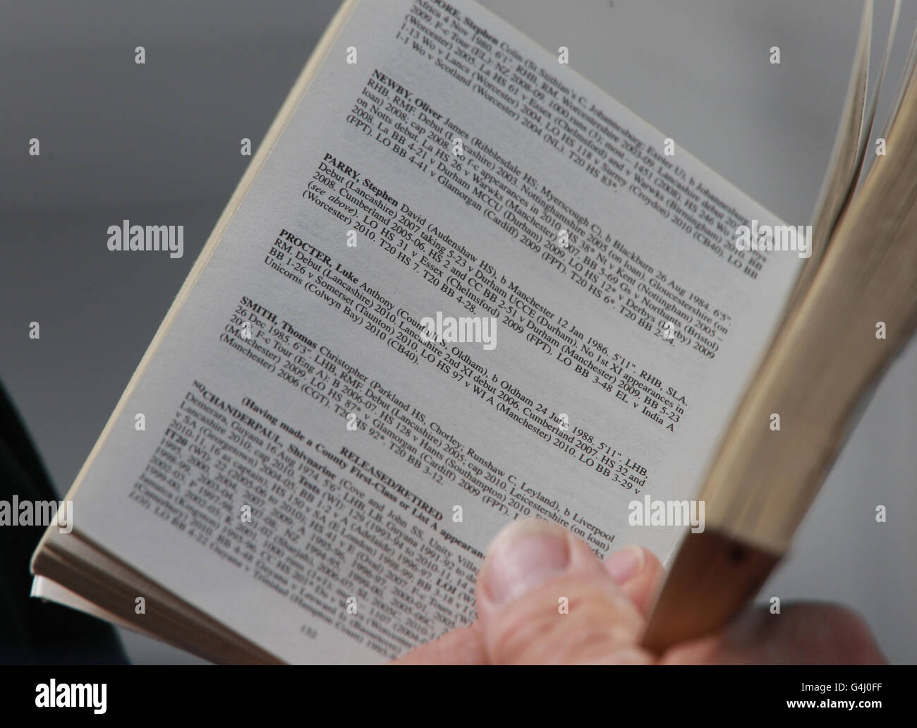 Un fan del cricket legge sui giocatori del Lancashire nel libro di cricket Playfair mentre guarda l'azione del LV County Championship, la prima partita della Divisione al County Ground, Taunton. Foto Stock