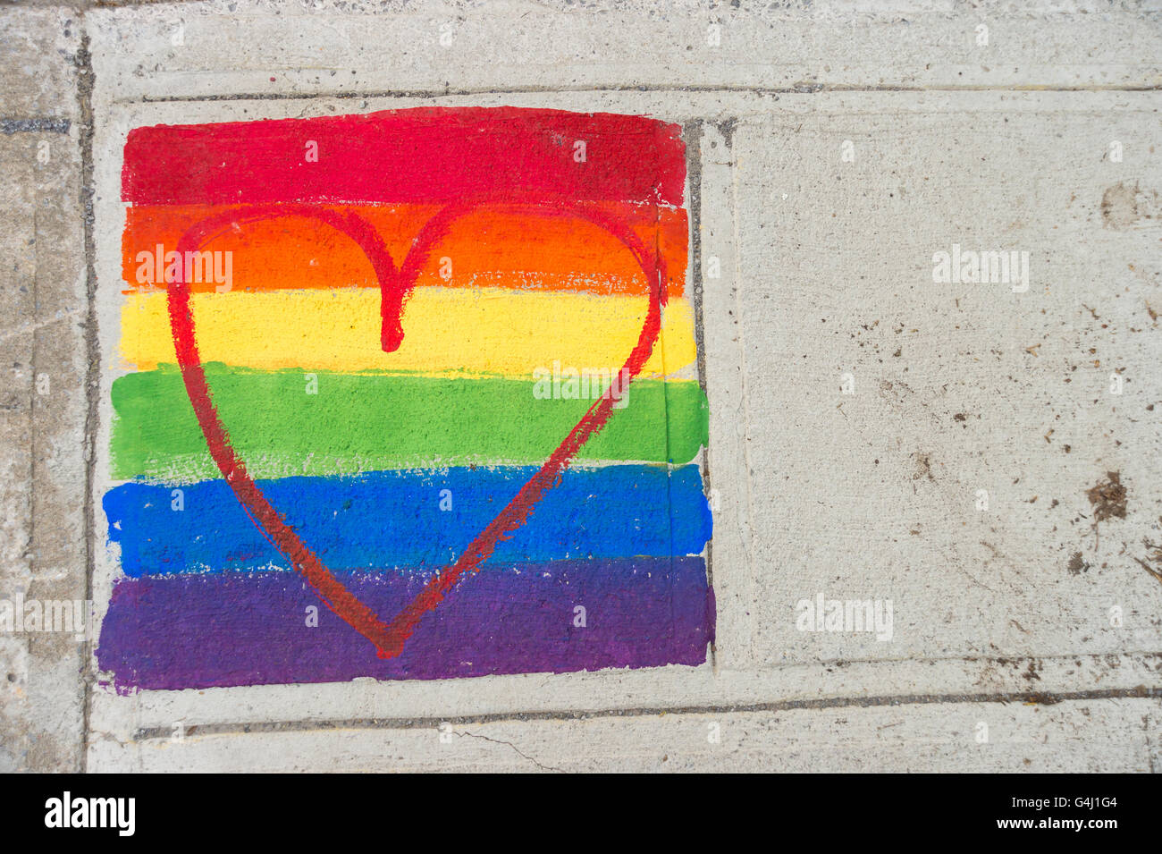 Gay-bandiera arcobaleno e cuore rosso dipinto su un marciapiede Foto Stock