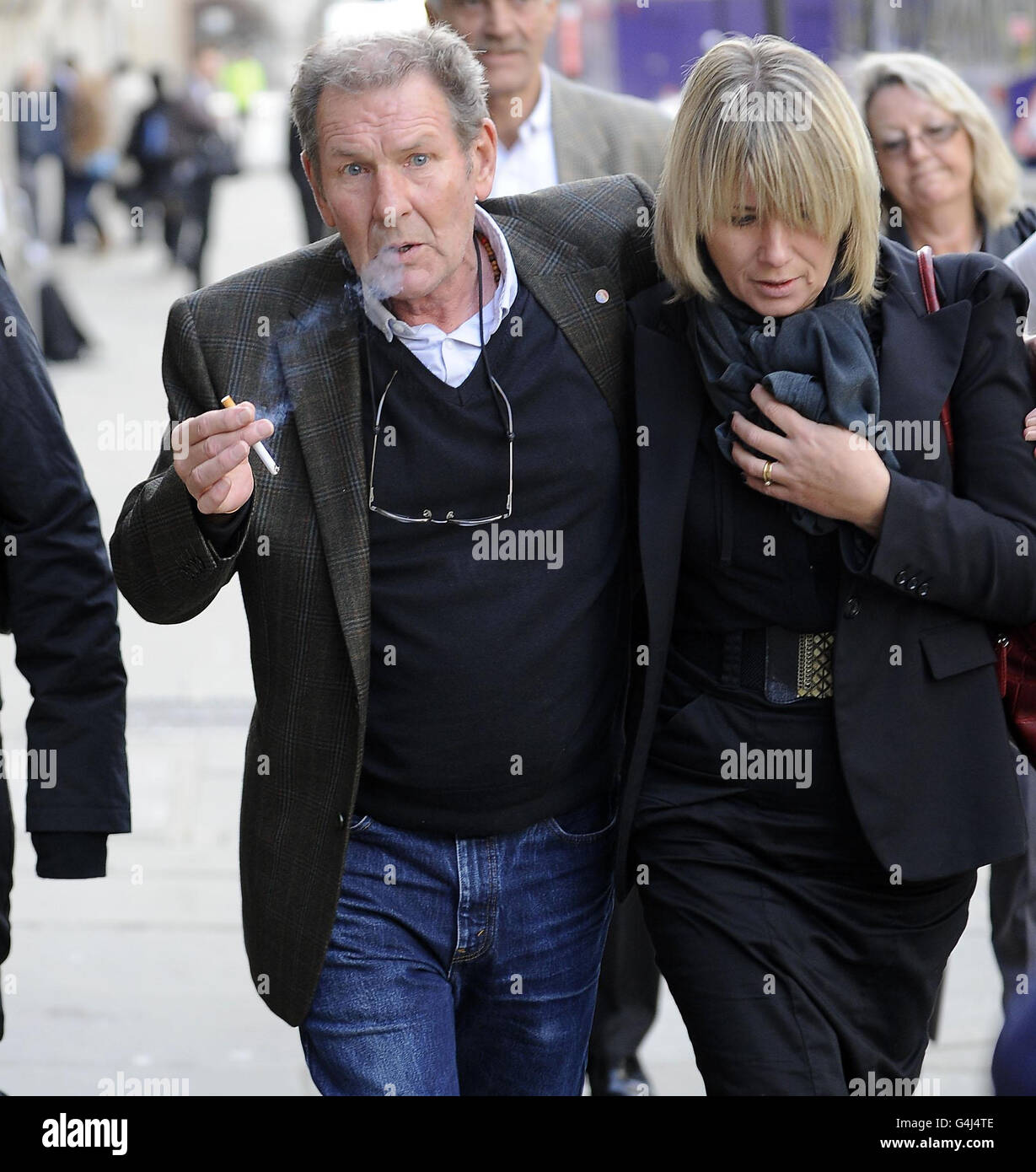 Stuart Mungall, 71 anni, di Tooting, a sud di Londra, (con una donna non identificata) lascia l'Old Bailey dopo aver ricevuto una sentenza di 12 mesi sospesa per due anni dopo aver dichiarato colpevole, in un'audizione precedente, al massacro della moglie malata al termine Joan, 69 a casa loro lo scorso dicembre, sulla base della ridotta responsabilità causata dalla depressione a seguito del carico di prendersi cura di lei. Foto Stock