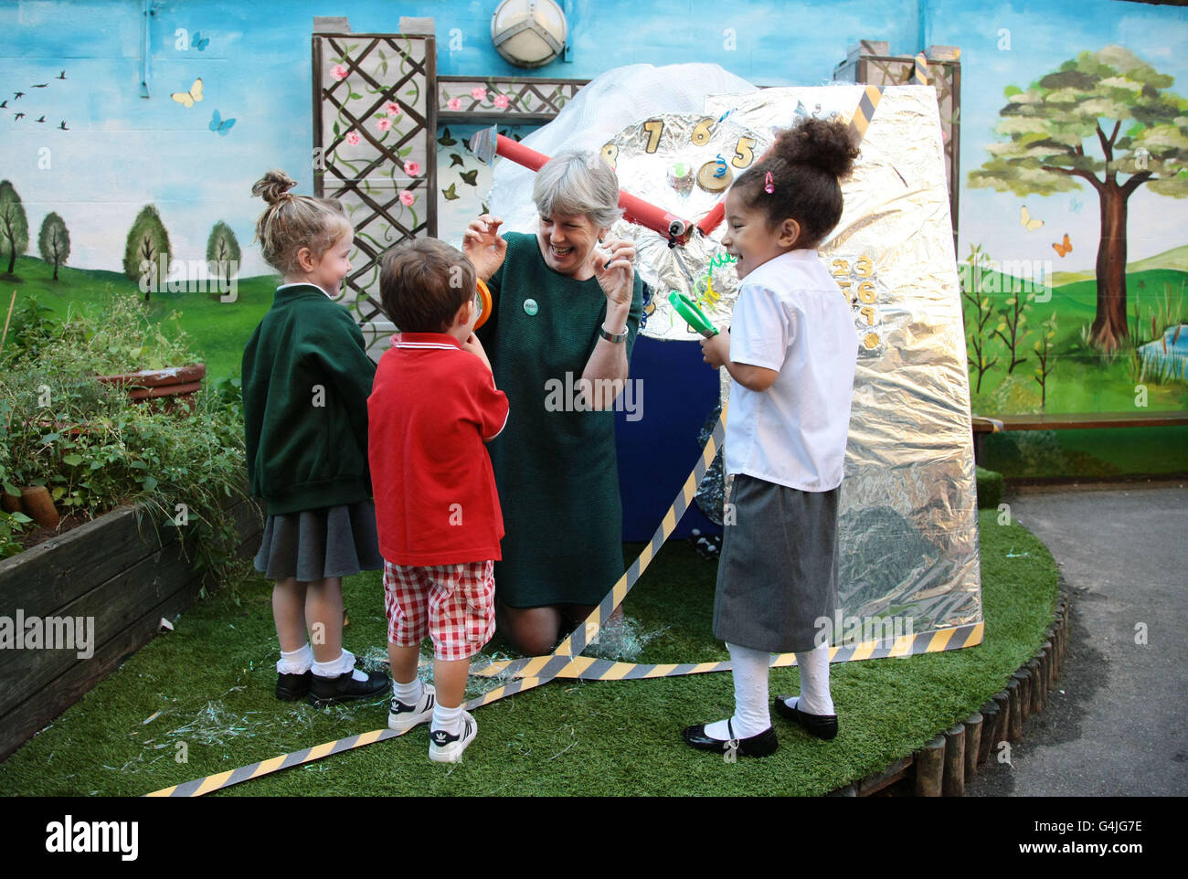 Jean Gross, campione della comunicazione per i bambini, agisce come straniero con i bambini della St Joseph's Primary School a Covent Garden, Londra, in una macchina del tempo costruita come parte di No Pens Day Mercoledì, un evento educativo unico in cui i bambini posano le penne per il giorno e si concentrano sulle attività di conversazione e ascolto. Foto Stock