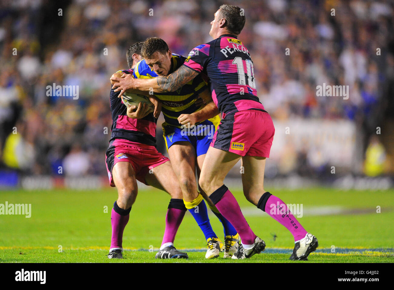 Simon Grix di Warrington Wolves viene affrontato da Danny Buderus di Leeds Rhinos e Jamie Peacock durante l'Engage Super League, semi Final match all'Halliwell Jones Stadium di Warrington. Foto Stock