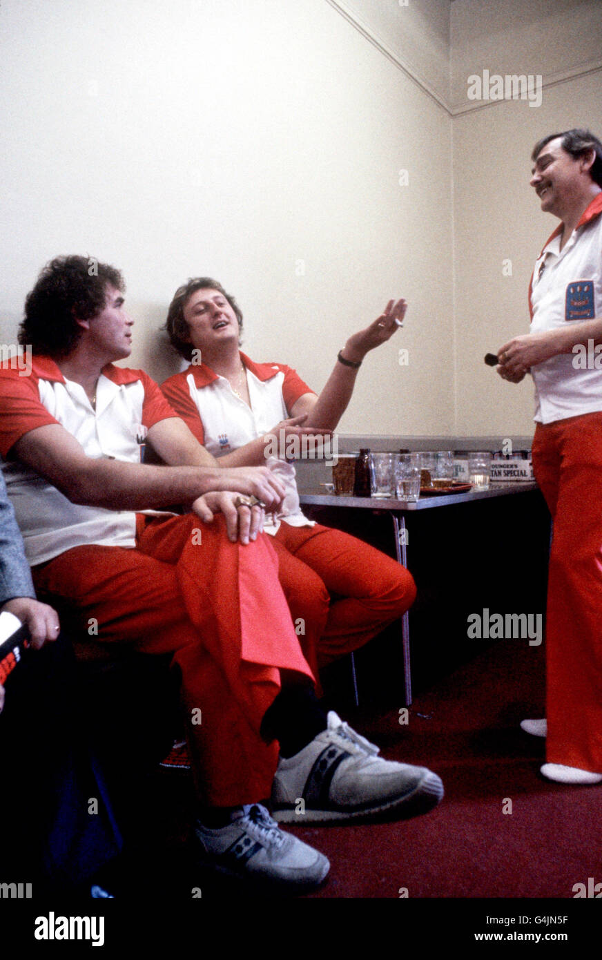 L'inglese Eric Bridow (c) spiega ai compagni di squadra Bobby George (l) E Alan Glazier (r) circa la ferita che del gomito ha sostenuto giocare freccette Foto Stock