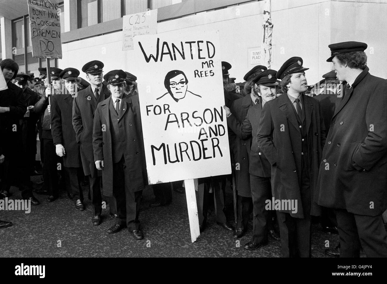PA NEWS PHOTO 26/11/77 UN BANNER CHE PORTA UN RITRATTO DEL SEGRETARIO DI CASA MERLYN REES E LE PAROLE 'VOLUTO PER ARSON E OMICIDIO' RAFFIGURA L'UMORE DI QUESTO GRUPPO DI VIGILI DEL FUOCO COME SI RIUNISCONO A LONDRA PRIMA DI UNA MARCIA DI MASSA AL N. 10 DOWNING STREET PER CONSEGNARE UNA PETIZIONE A. IL PRIMO MINISTRO, SOSTENENDO LA RICHIESTA DI IR PER UNA MAGGIORE RETRIBUZIONE Foto Stock