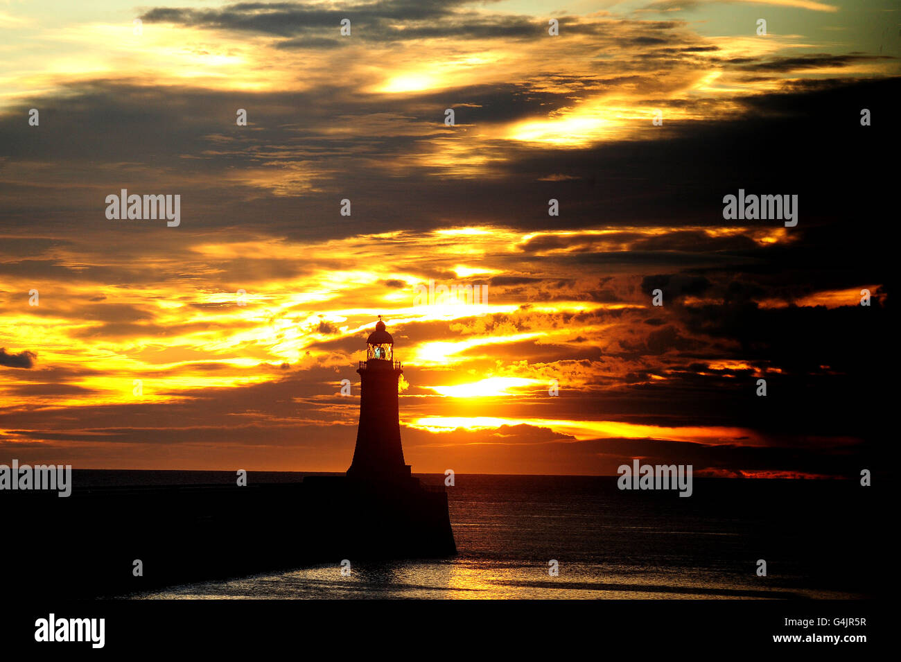 Il sole d'autunno sorge sul molo di Tynemouth a Tyne e indossa. Foto Stock