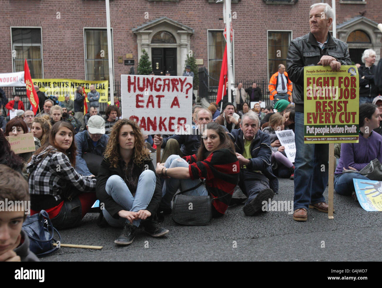 I dimostranti in una protesta siedono contro il sistema finanziario globale al di fuori dell'hotel Marrion a Dublino, dove soggiornano i membri del team finanziario FMI/UE. Foto Stock