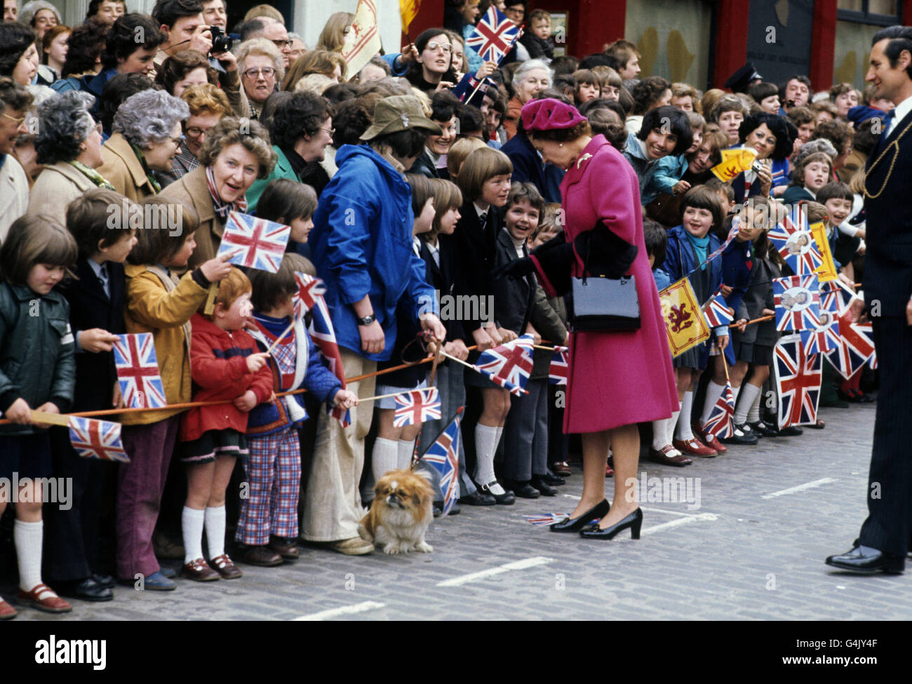 Un patriottico pekingese tra la folla che sventola la bandiera a Perth in attesa dell'arrivo della Regina Elisabetta II, durante il suo Silver Jubilee Tour of Britain. Foto Stock