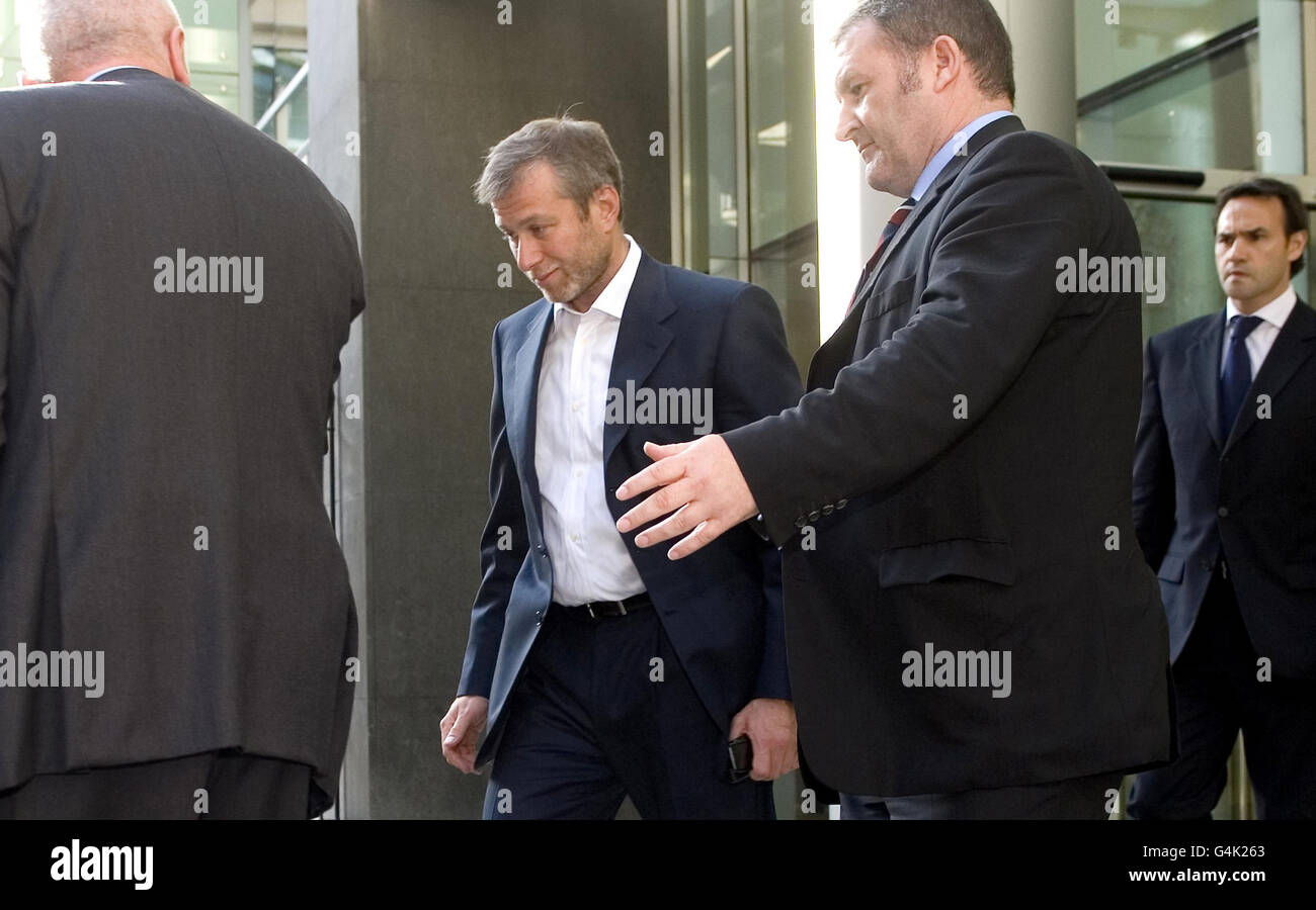 Il proprietario del Chelsea Football Club Roman Abramovich (centro) lascia il Tribunale commerciale dell'alta Corte nel centro di Londra, affiancato dalle guardie di sicurezza. Foto Stock