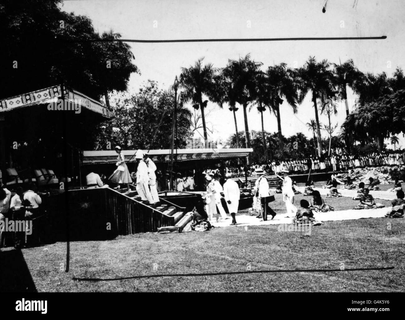 **scannerizzate a bassa risoluzione dal contatto** la Regina e Duca di Edimburgo fanno la loro strada sul dais di bambù in Albert Park, Suva, passato una guardia d'onore di squatting donne indigene. Foto Stock
